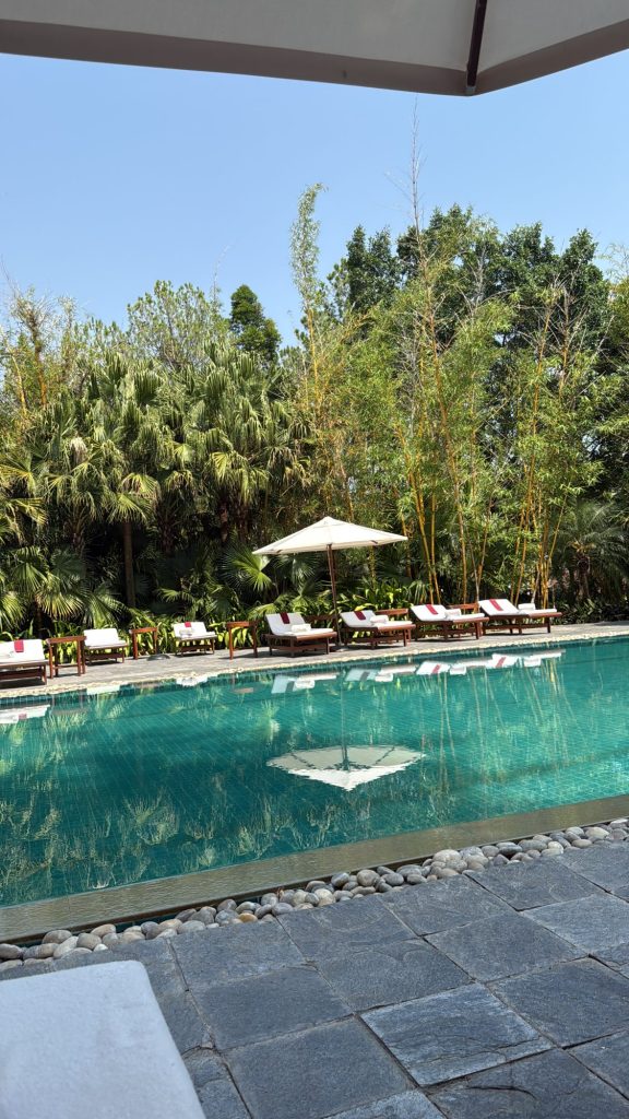 Outdoor pool surrounded by palms and bamboo at Ananda in the Himalayas
